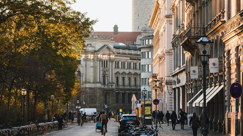 Das Foto zeigt einen Blick in eine Straße zwischen großen und alten Gebäuden. 